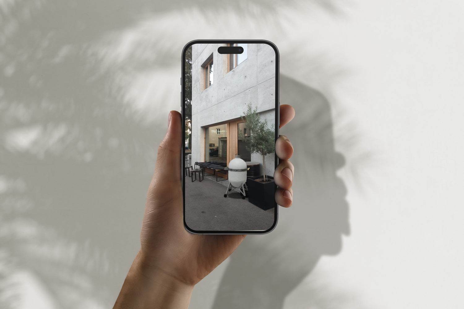 Compadre Grillofen mit Mobiltelefon virtuell vor moderne Bar gestellt